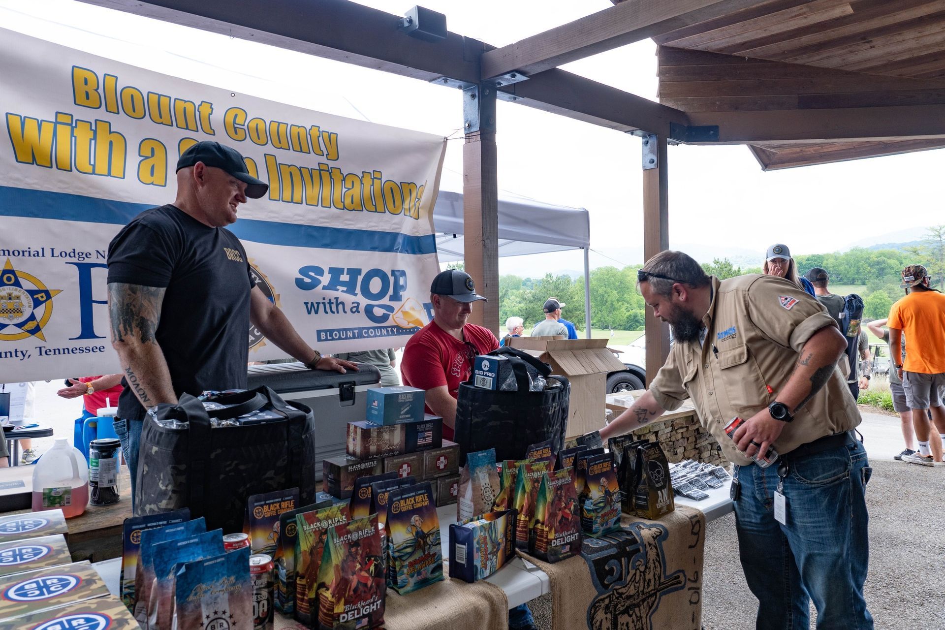 A group of men are standing around a table with boxes of fireworks.