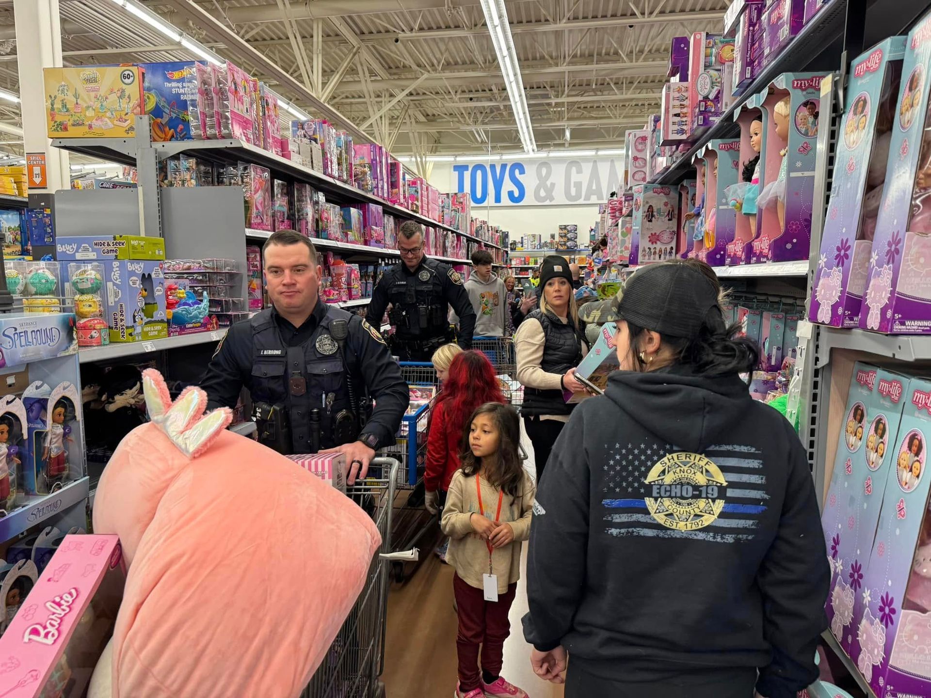 A group of people are shopping in a toys and games store.