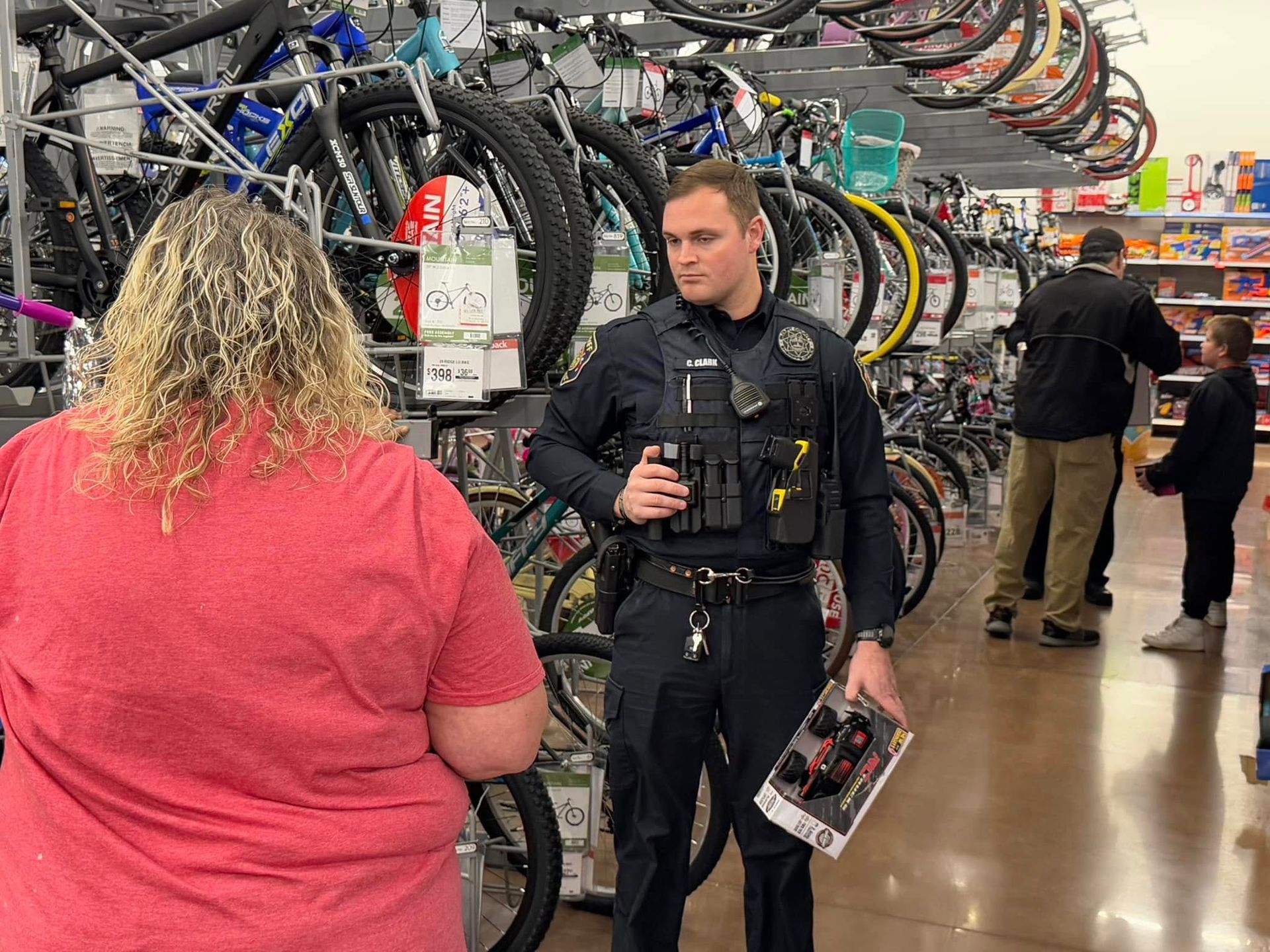 A police officer is talking to a woman in a store.