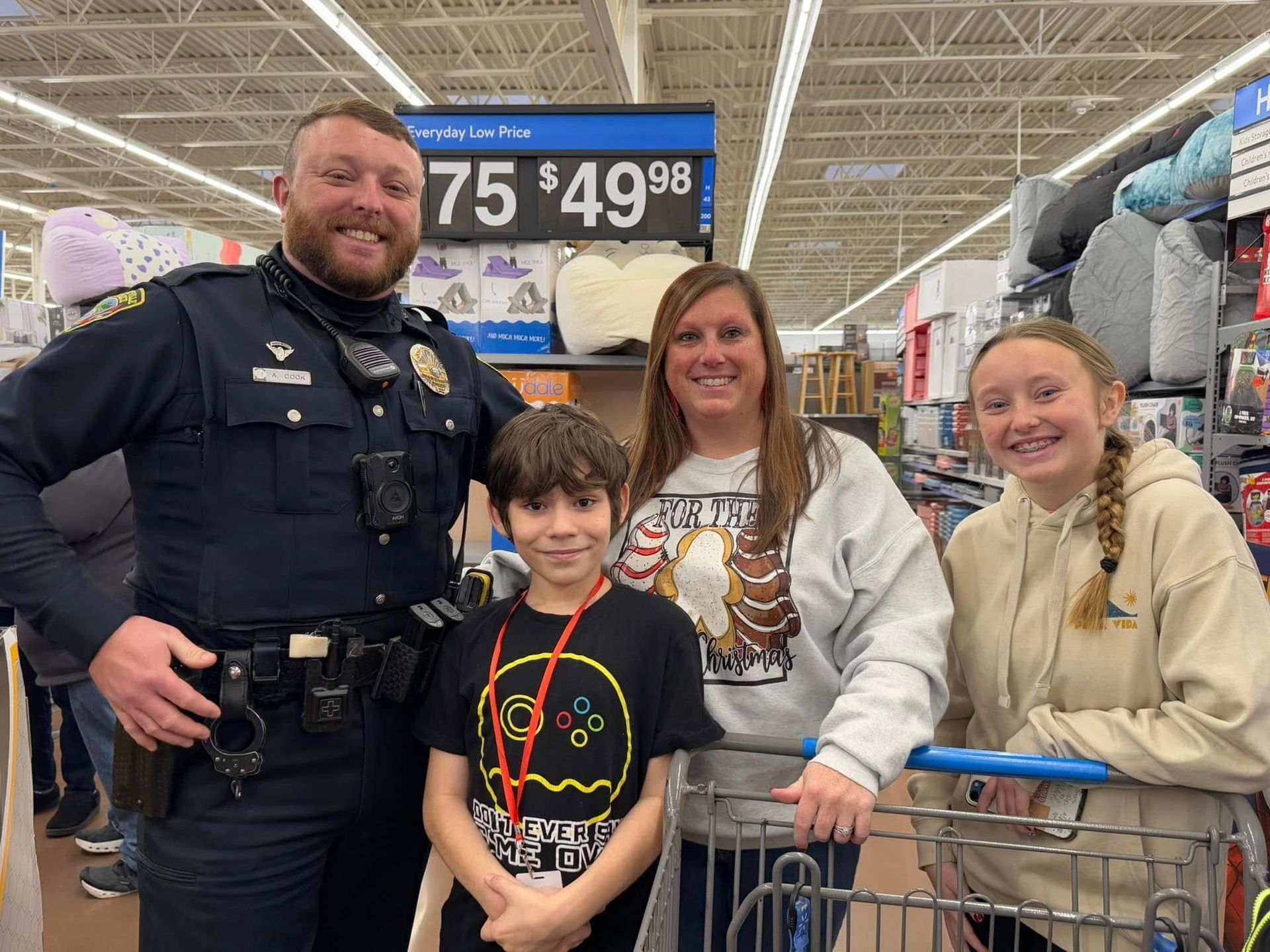 A police officer is posing for a picture with a family in a store.