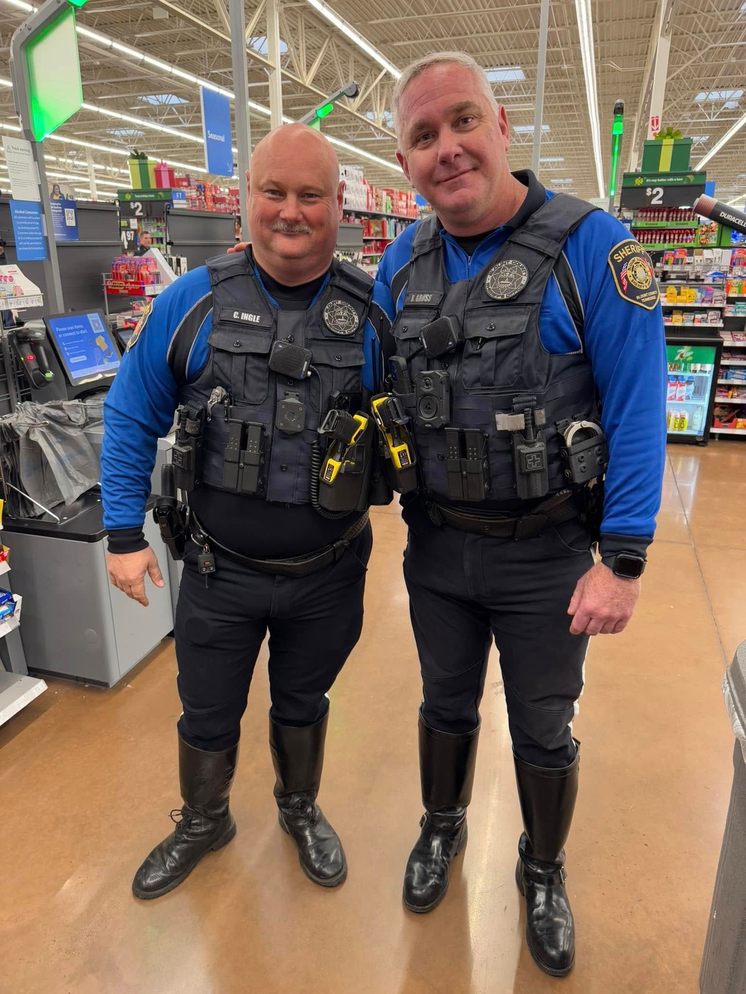 Two police officers are standing next to each other in a store.