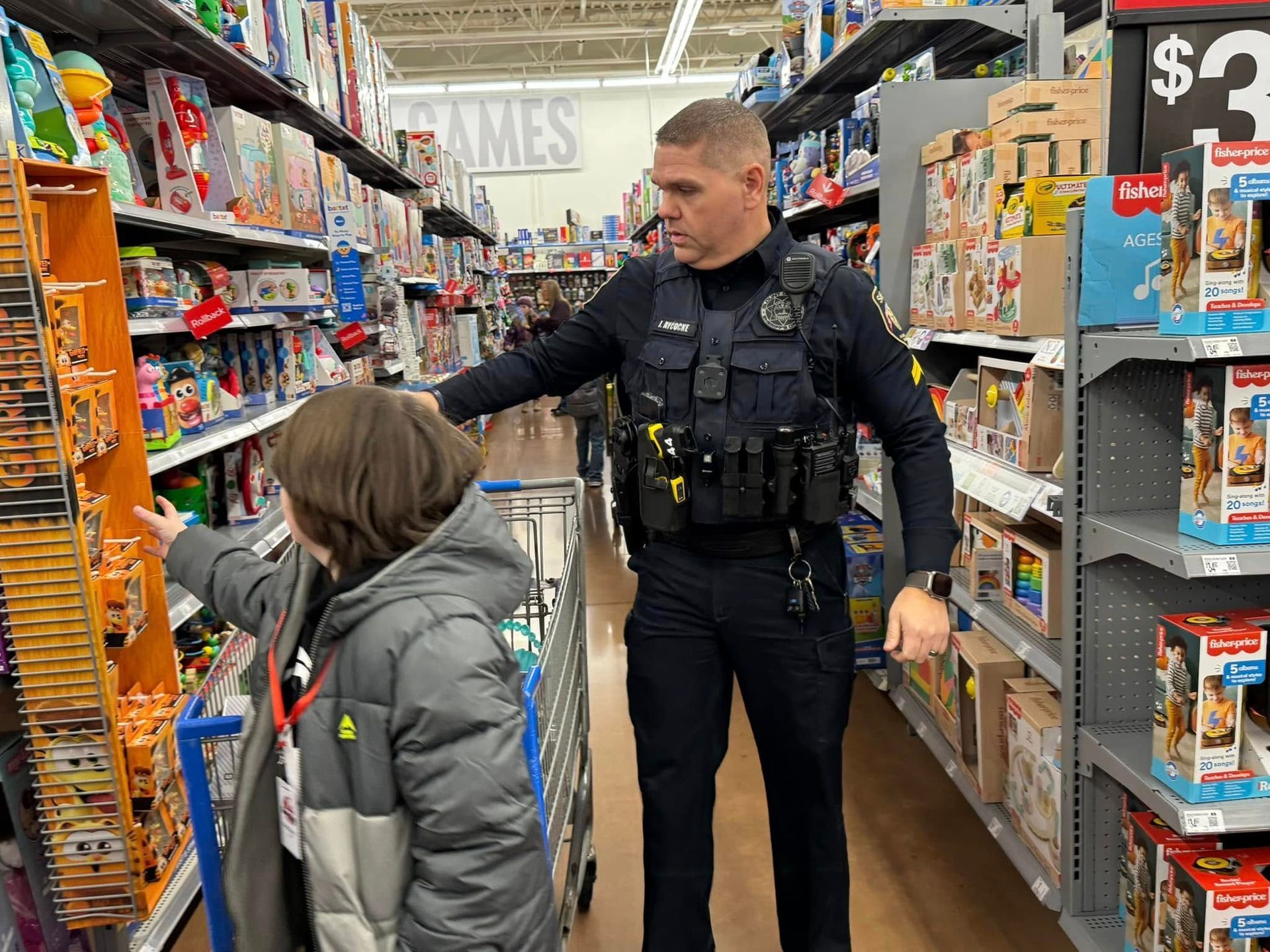 A police officer is helping a child push a shopping cart in a store.