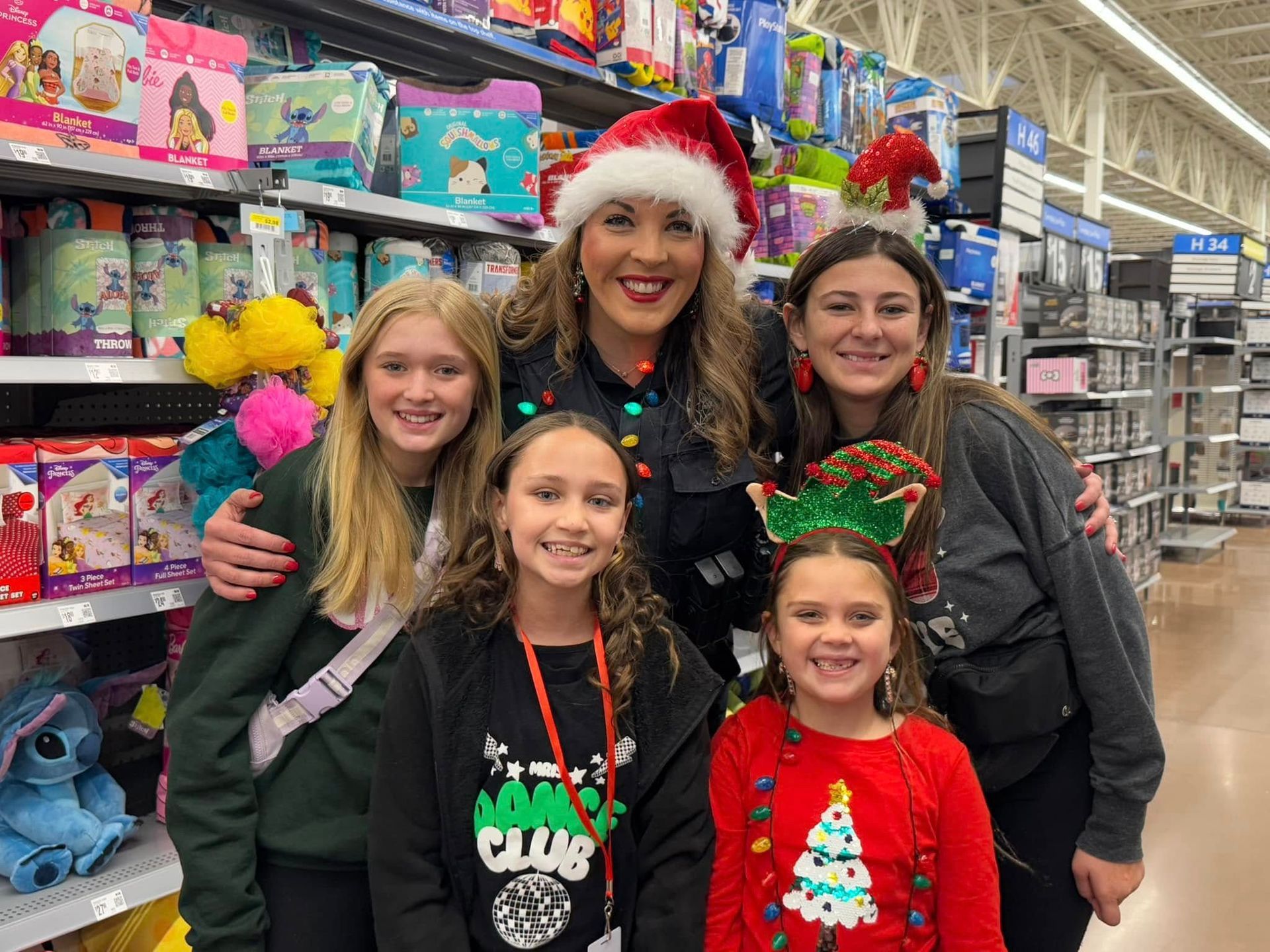 A woman and three girls are posing for a picture in a store.