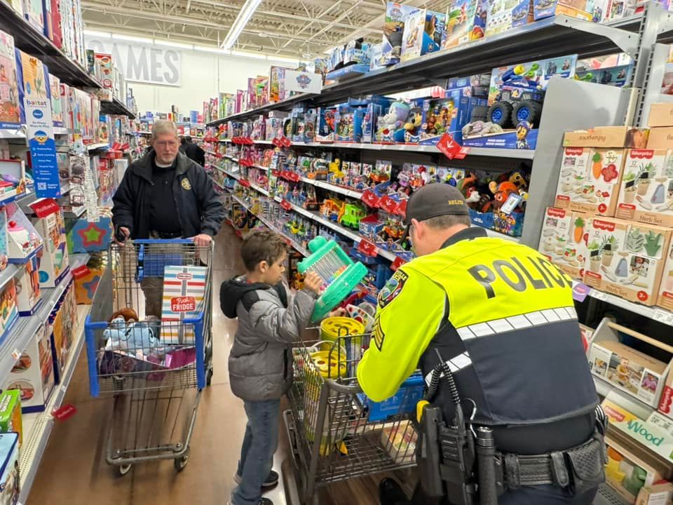 A police officer is talking to a child in a toy store.
