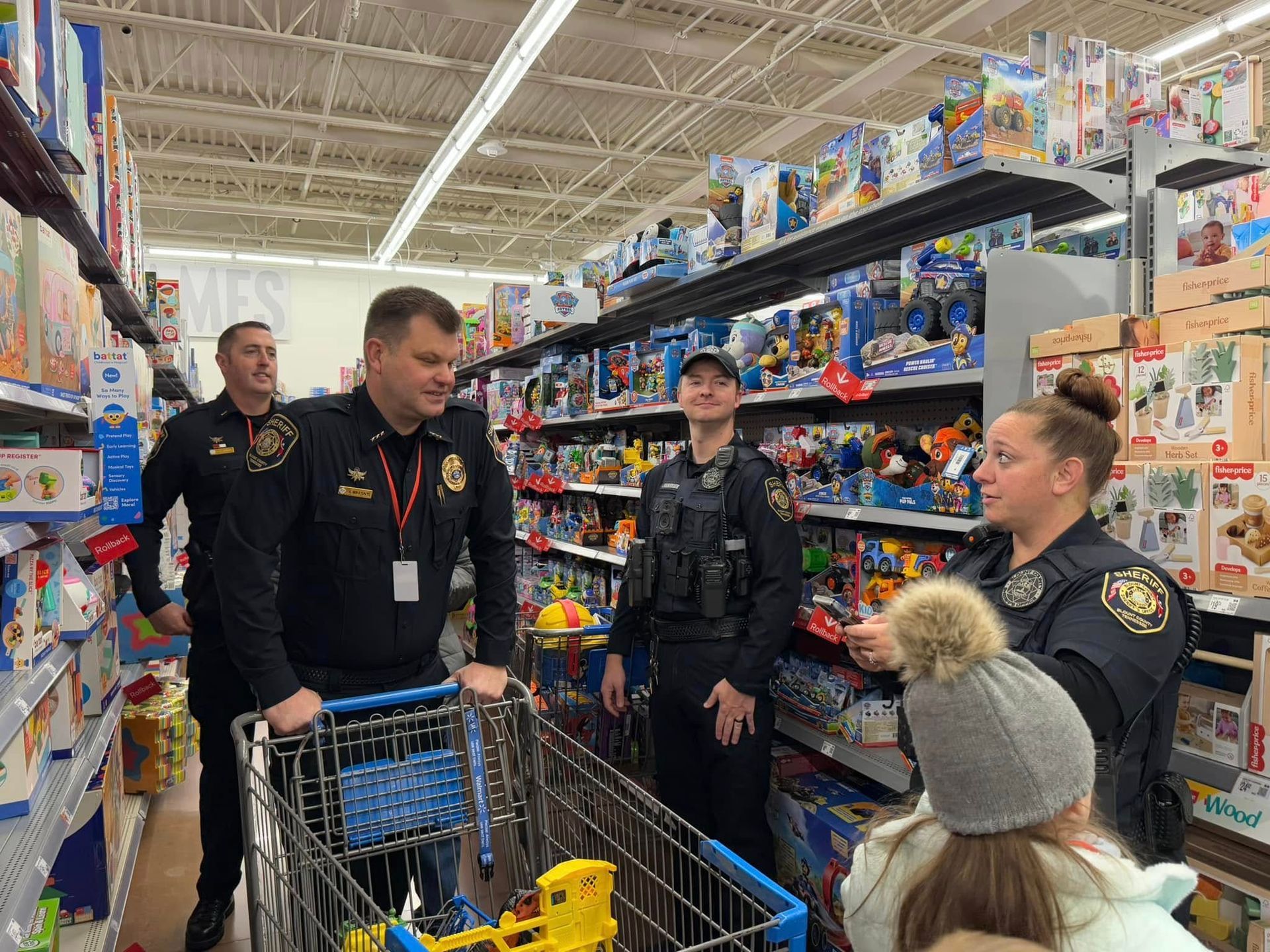 A group of police officers are standing around a shopping cart in a store.