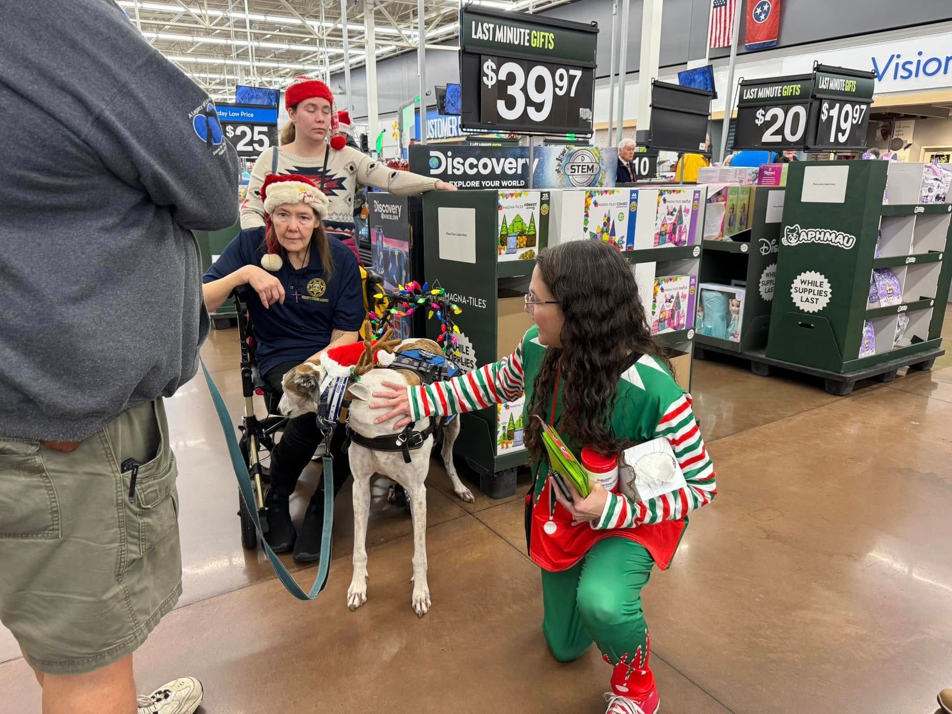 A woman in a wheelchair is holding a dog in a store.