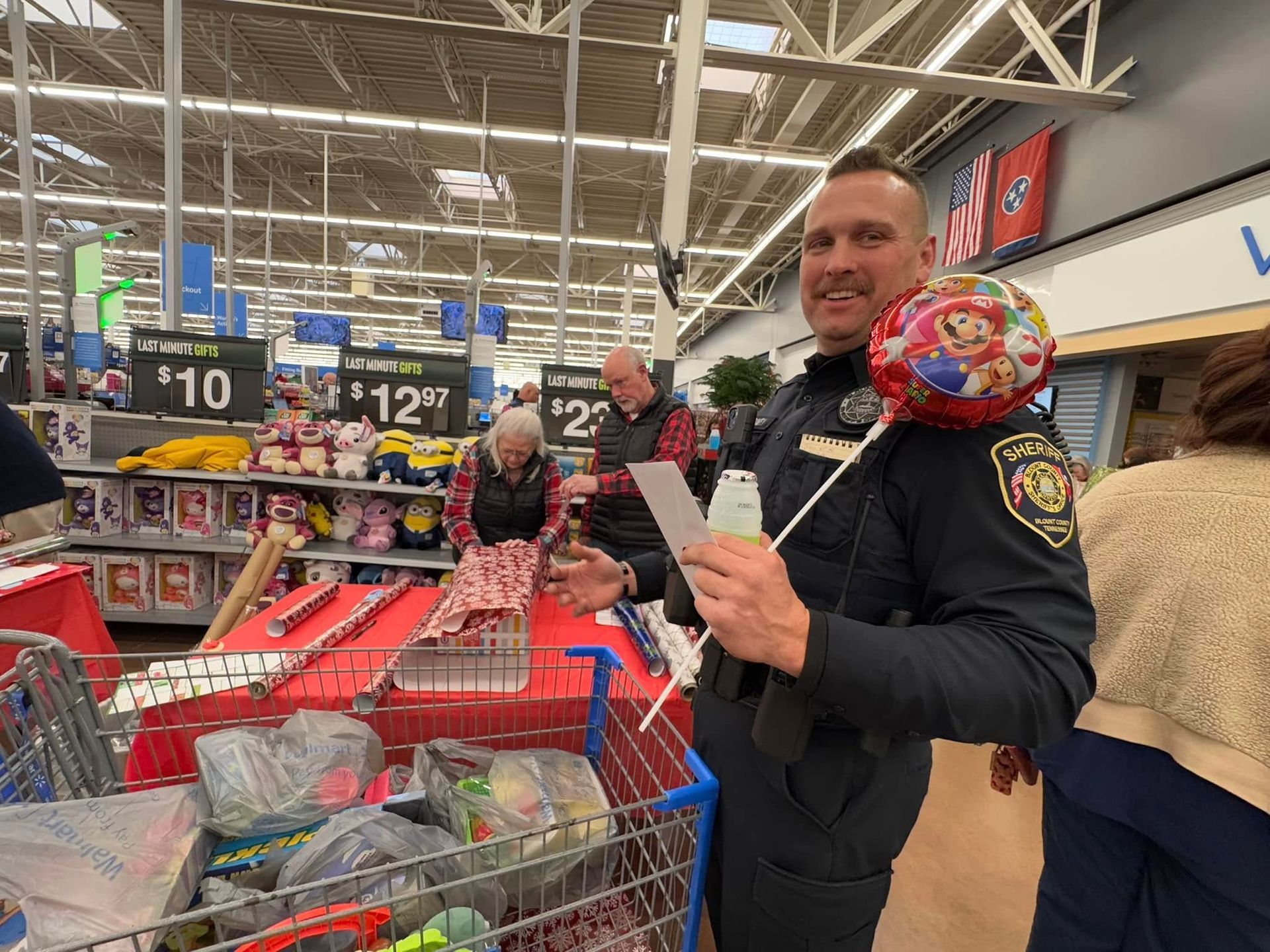 A police officer is standing next to a shopping cart in a store.