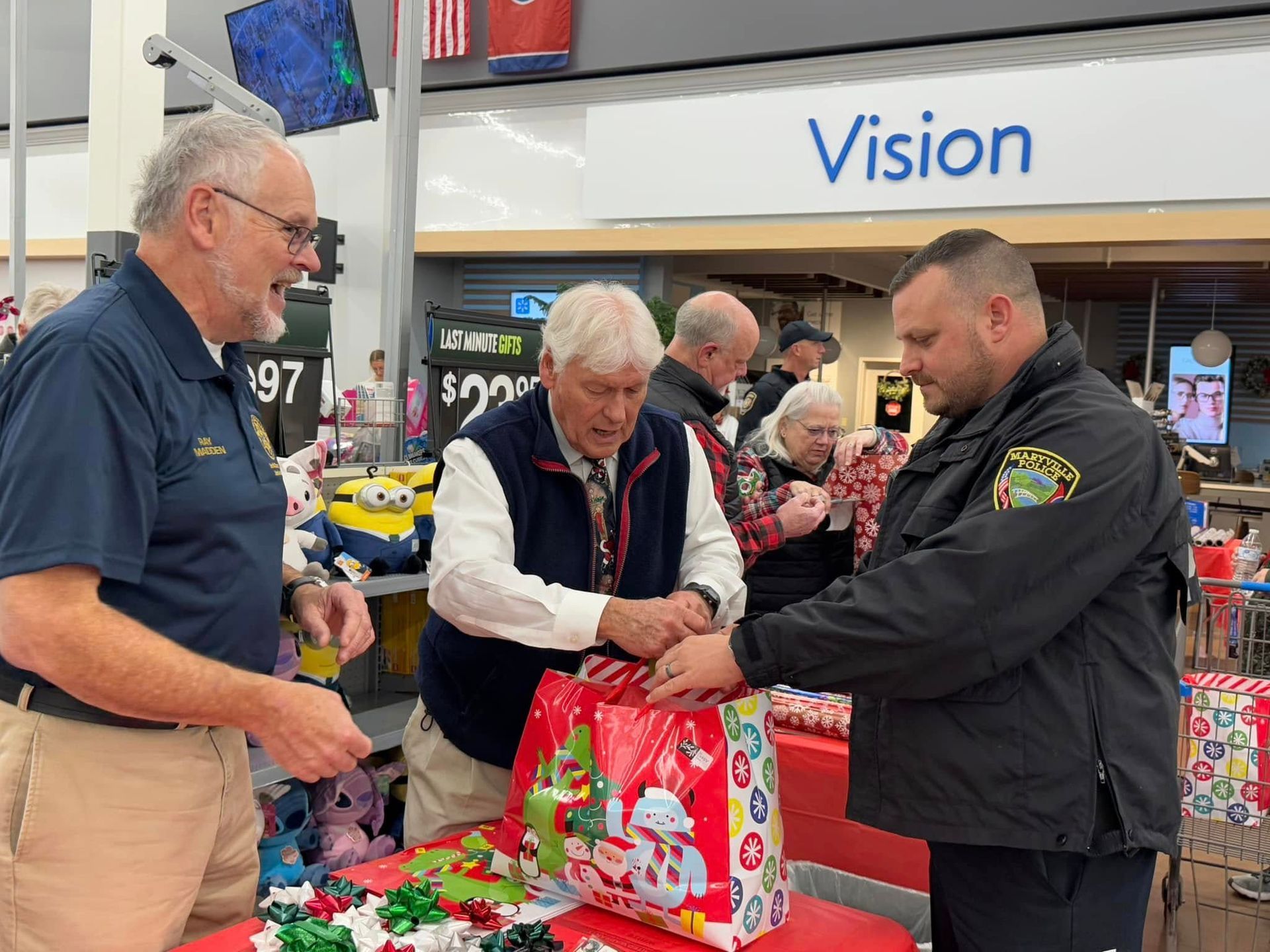 A group of men are standing around a table in a store.