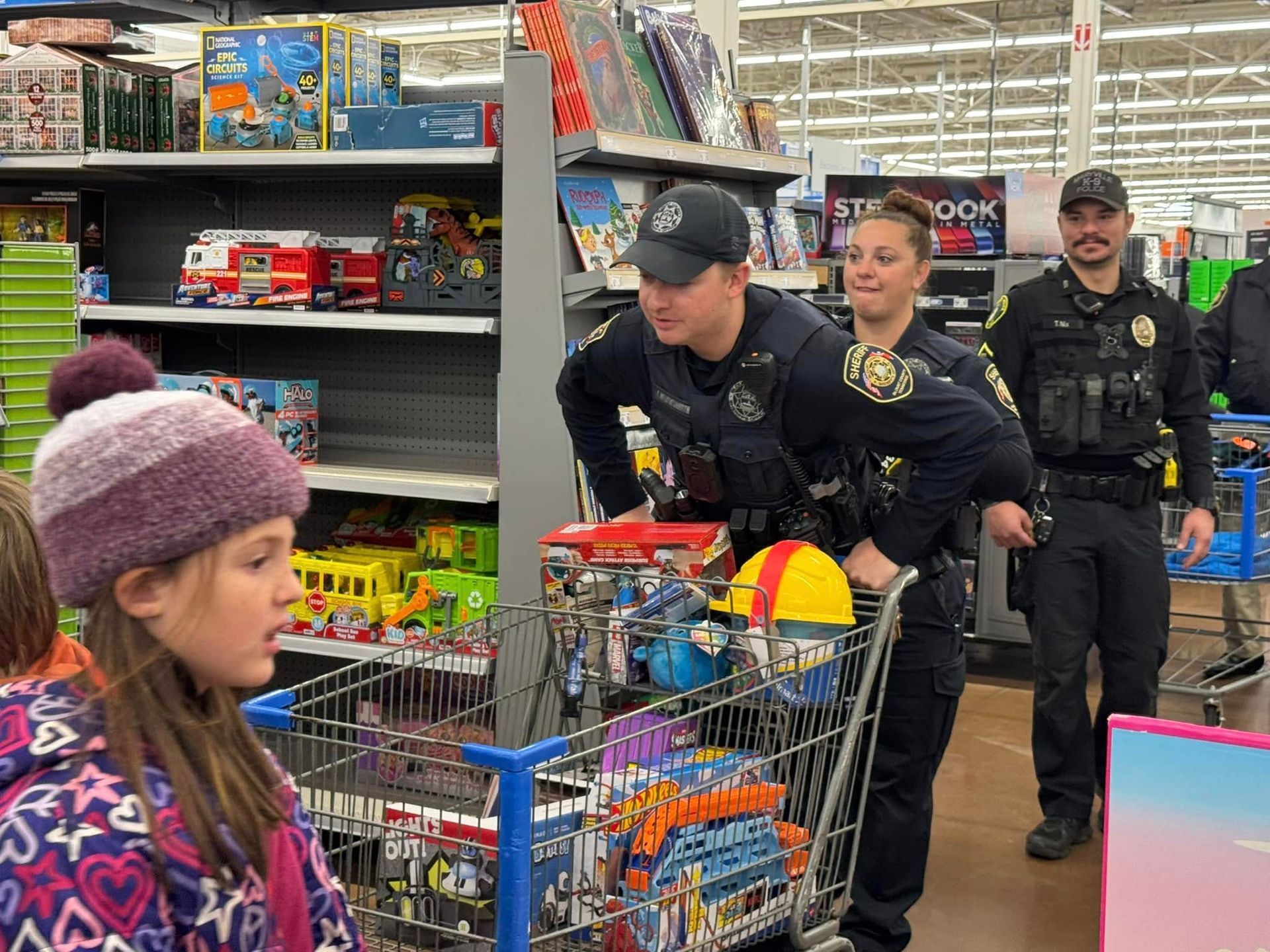 A group of police officers are standing around a shopping cart in a store.
