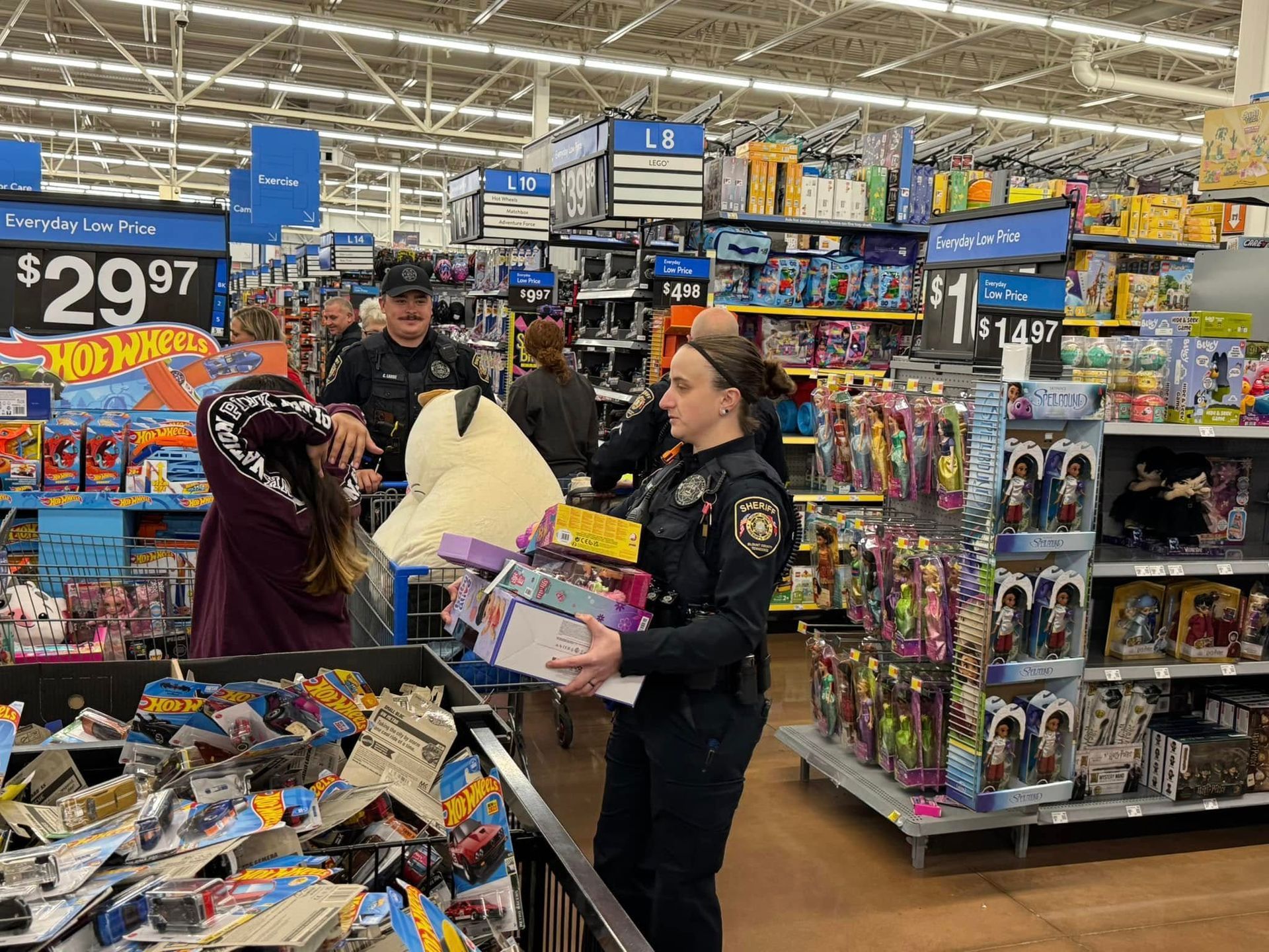 A police officer is standing in a toy section of a store.