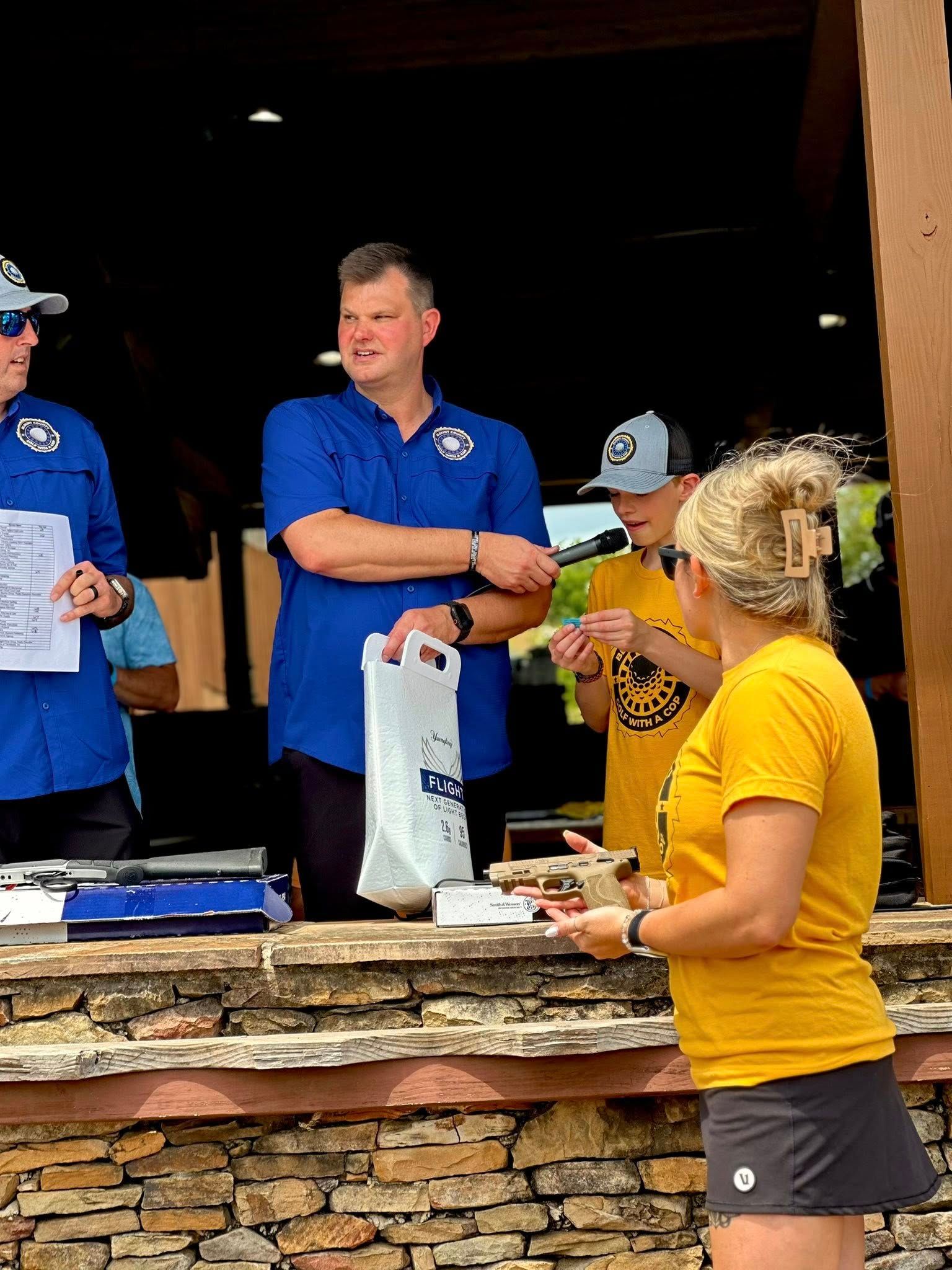 A group of people are standing around a counter talking to each other.
