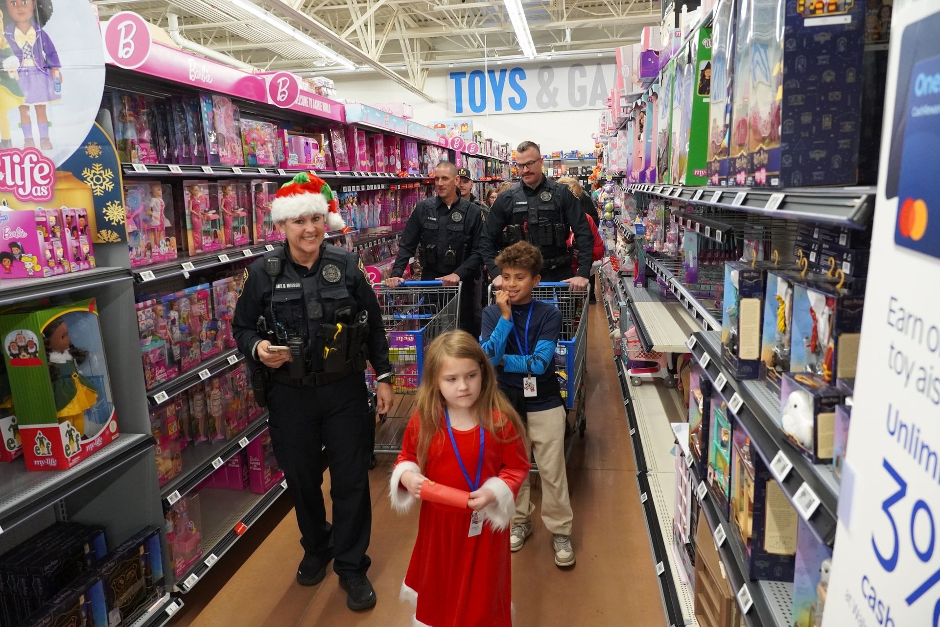 Police officers with children shopping in a toy aisle.
