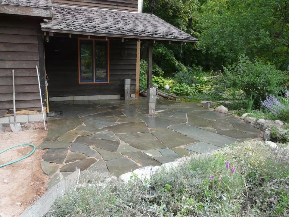 A house with a stone patio in front of it