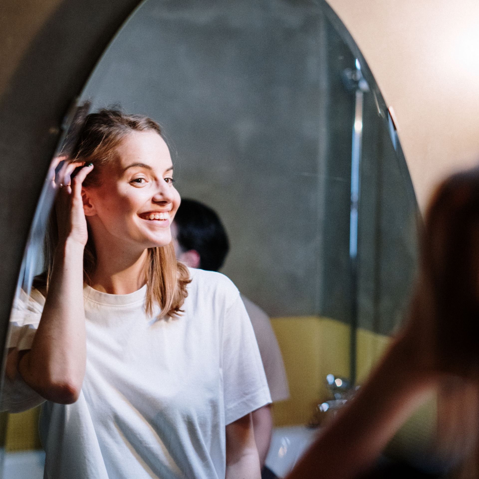 Woman looking at her new smile in the mirror