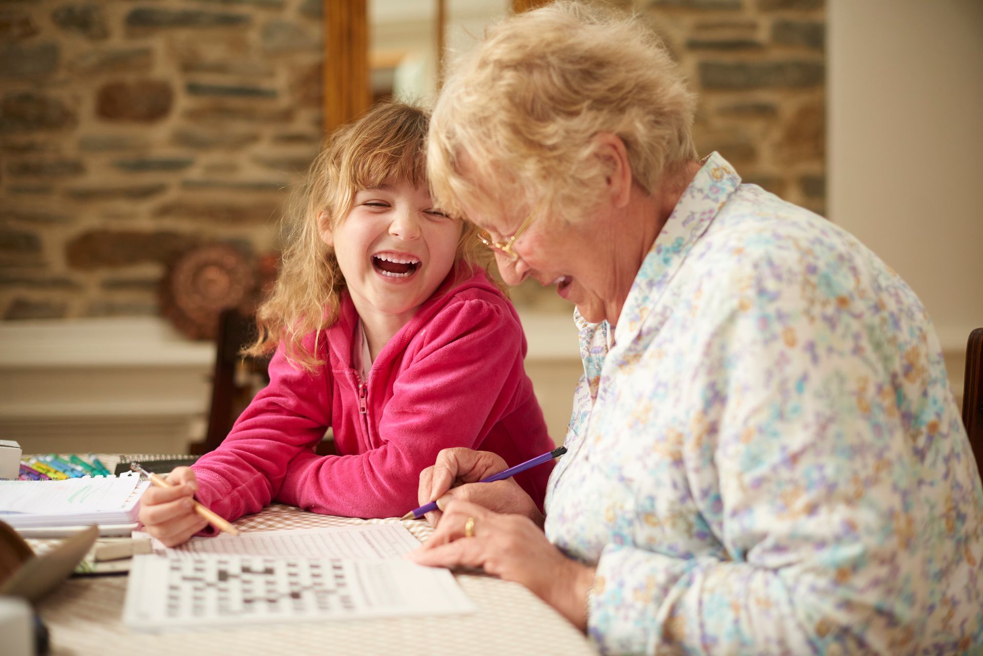 An elderly woman and a young girl are sitting at a table.