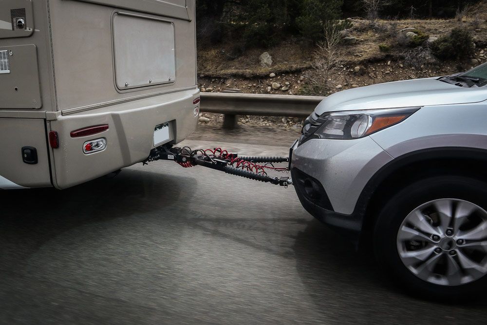 A Silver Suv Is Towing A Trailer On A Highway — Tim's Towing and Transport In Bulga, NSW