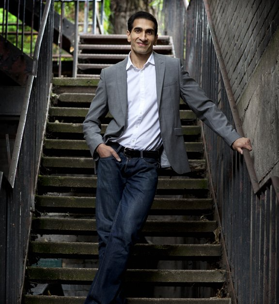 Ravi Summan, wearing grey blazer, and blue jeans