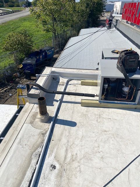 commercial refrigeration unit being worked on from the roof