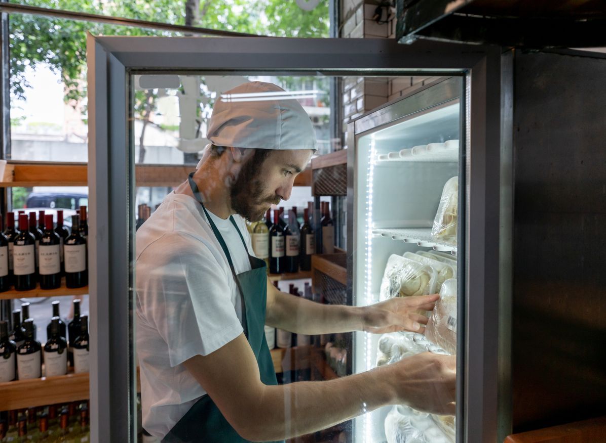 Employee adding product to refrigerator in Philadelphia, PA