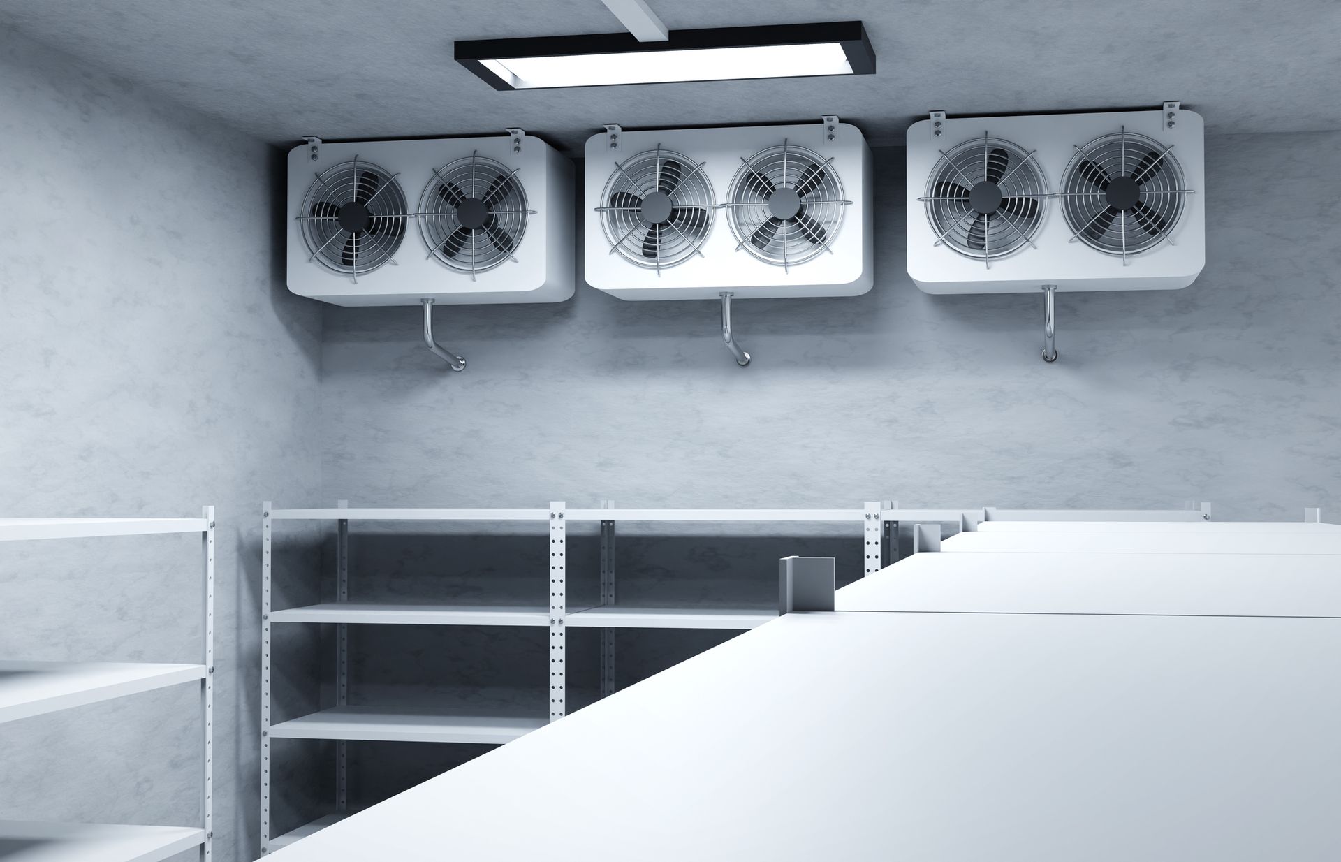 A walk-in freezer with three cooling units, shelving, and a fluorescent light.