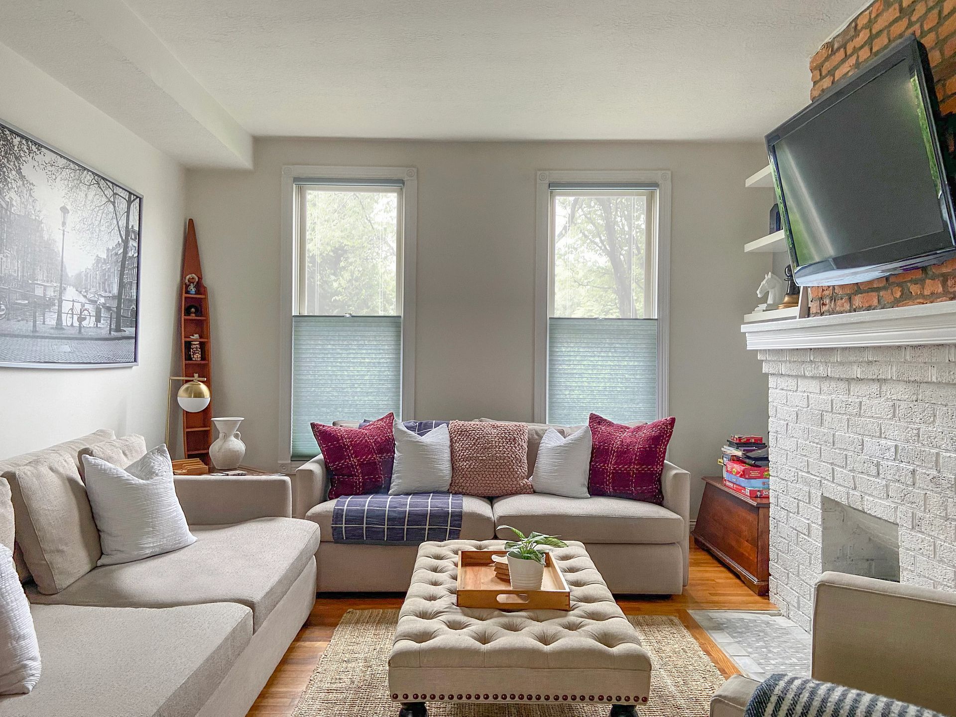 Dark-framed window with white mesh roller shades against a teal wall. The room has a gray carpet.