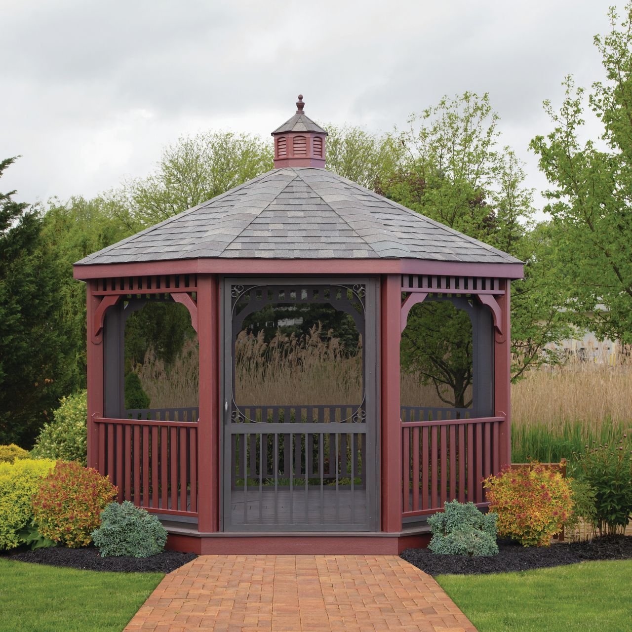 a gazebo with a screen door and a brick walkway leading to it