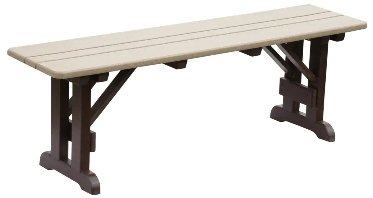 A white shed with a black roof is sitting in the middle of a lush green field.