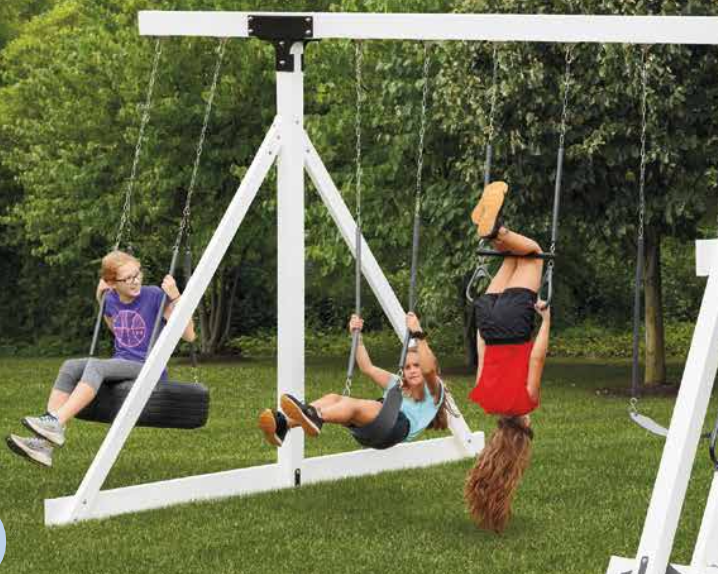 A small house with a black roof is sitting in the middle of a lush green field.