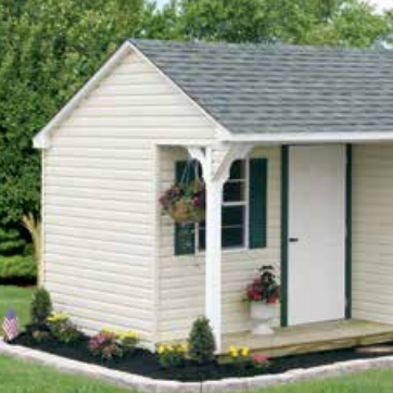 Tan shed with three windows, oval window, and shingled roof, set against trees.