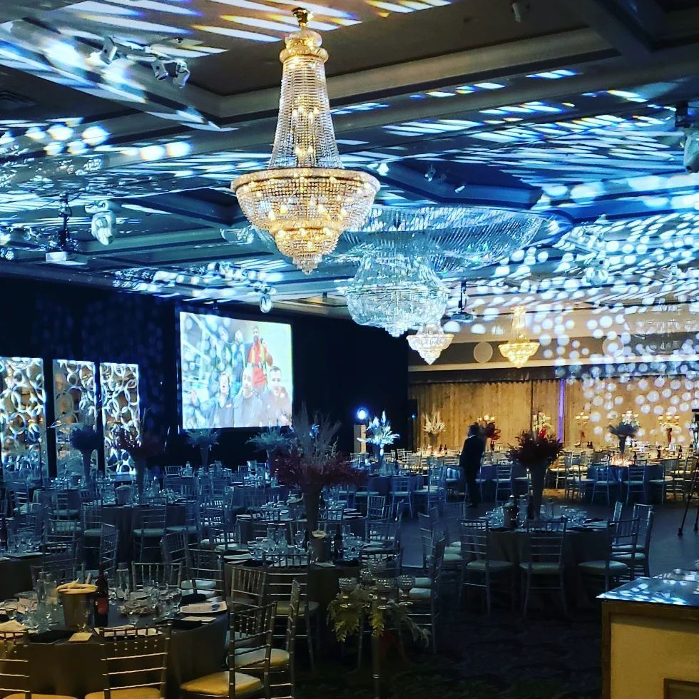 a large room with tables and chairs and a chandelier hanging from the ceiling