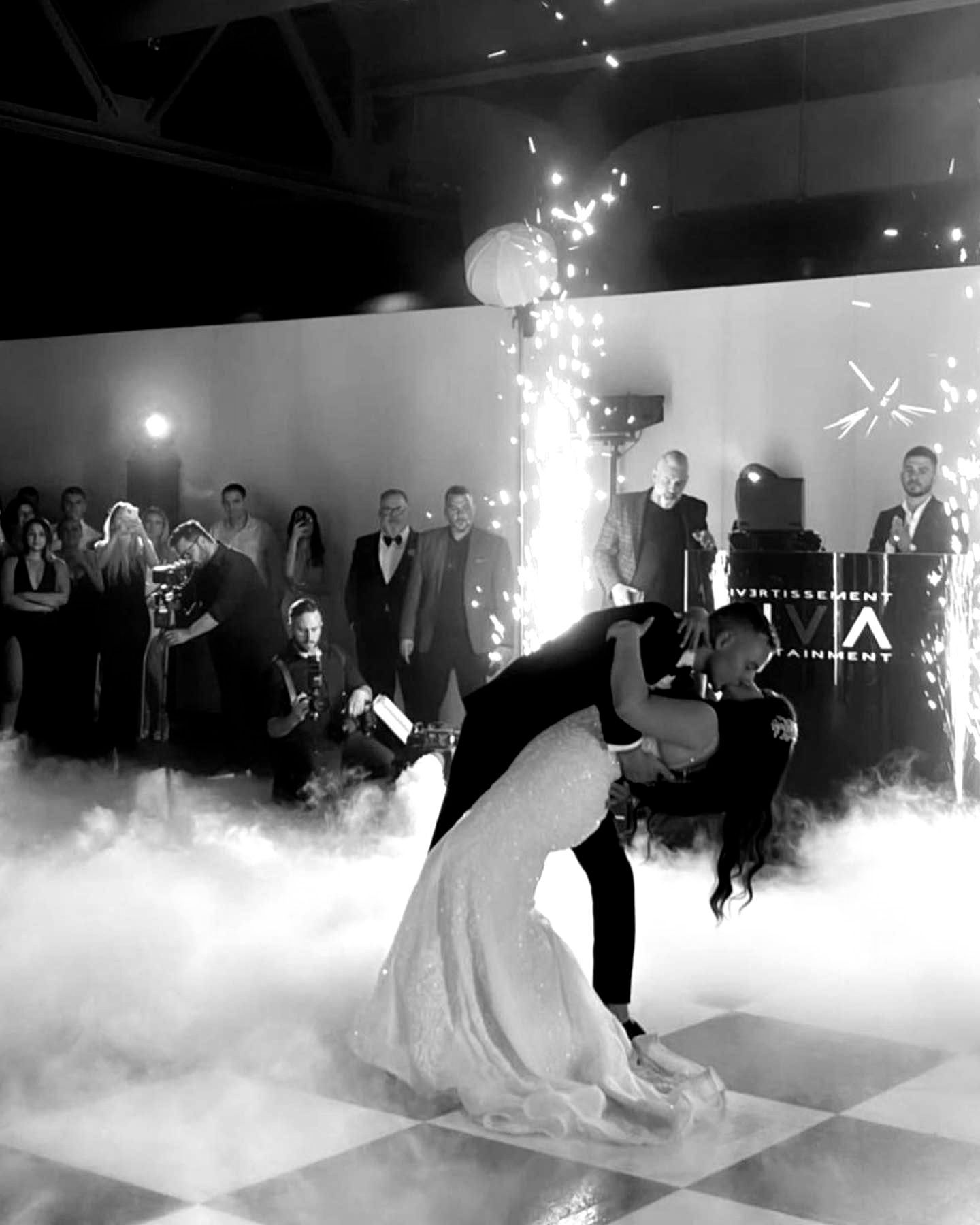 a black and white photo of a bride and groom dancing