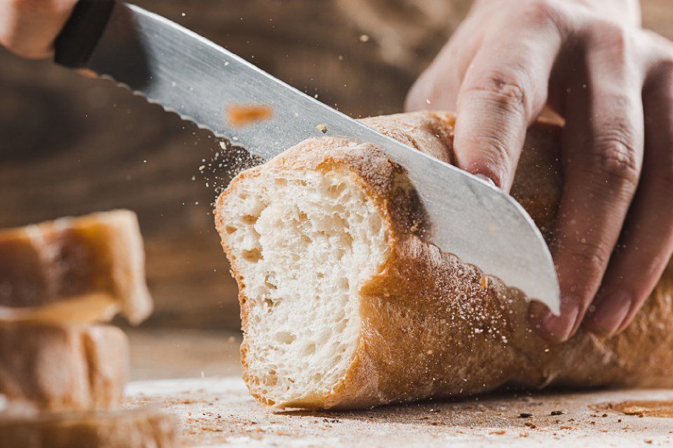 Loaf of bread being sliced with a knife