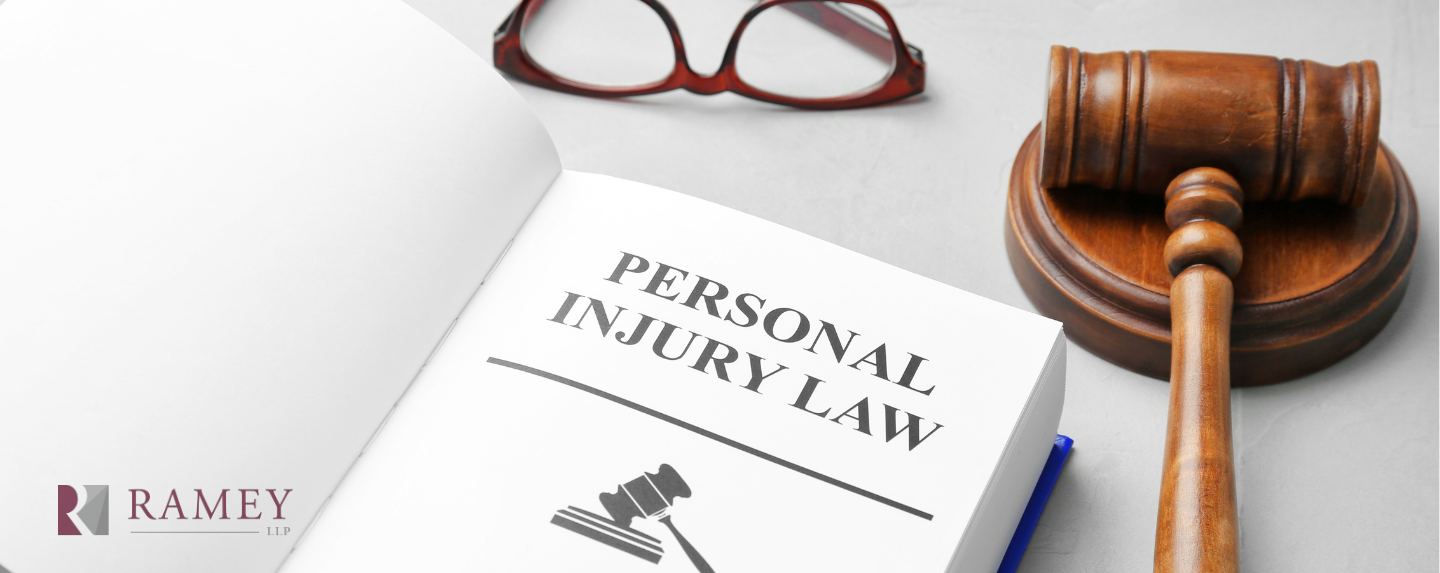 A book about personal injury law is sitting on a table next to a judge 's gavel and glasses.