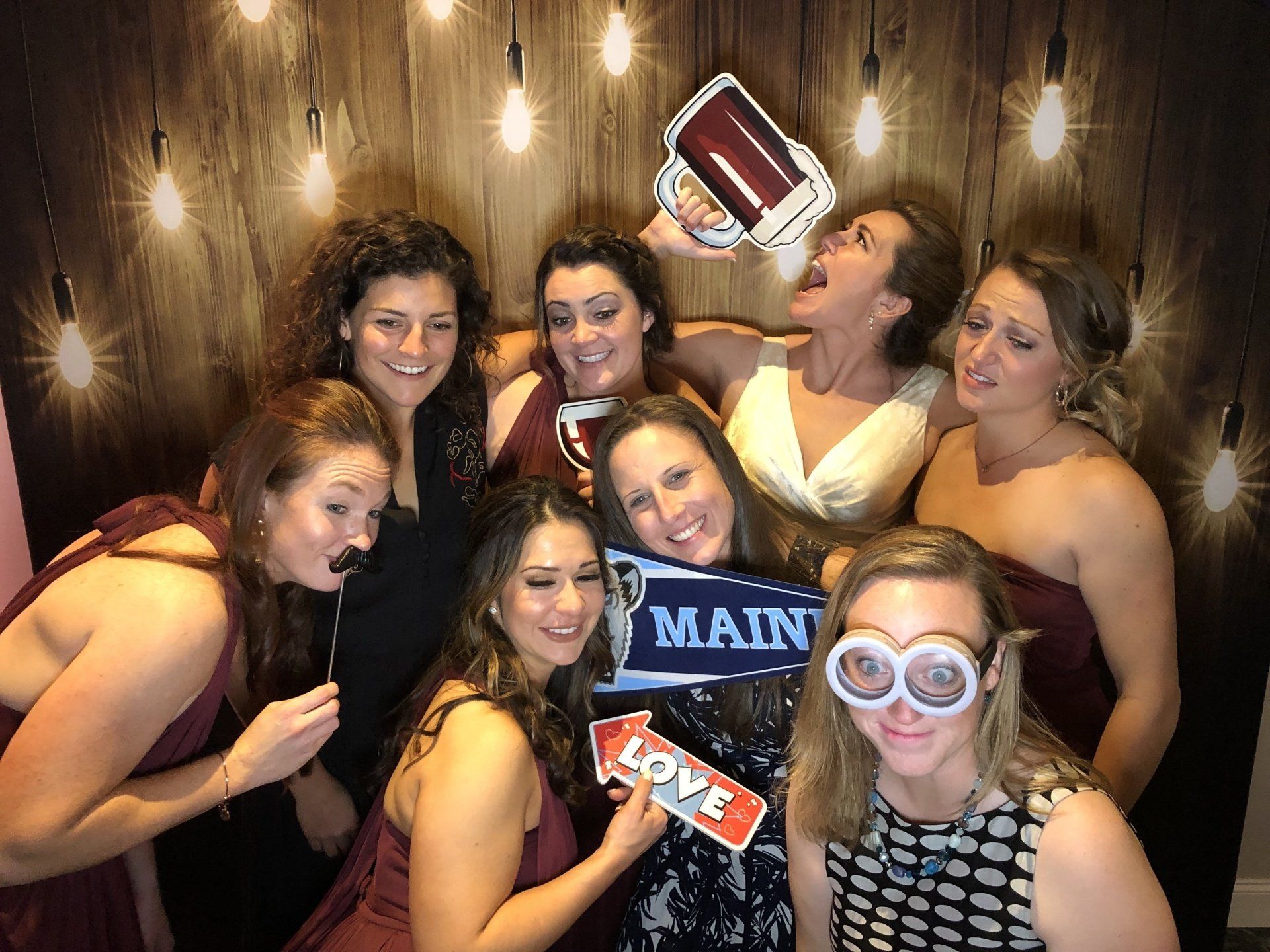 wedding guests in a photo booth holding signs