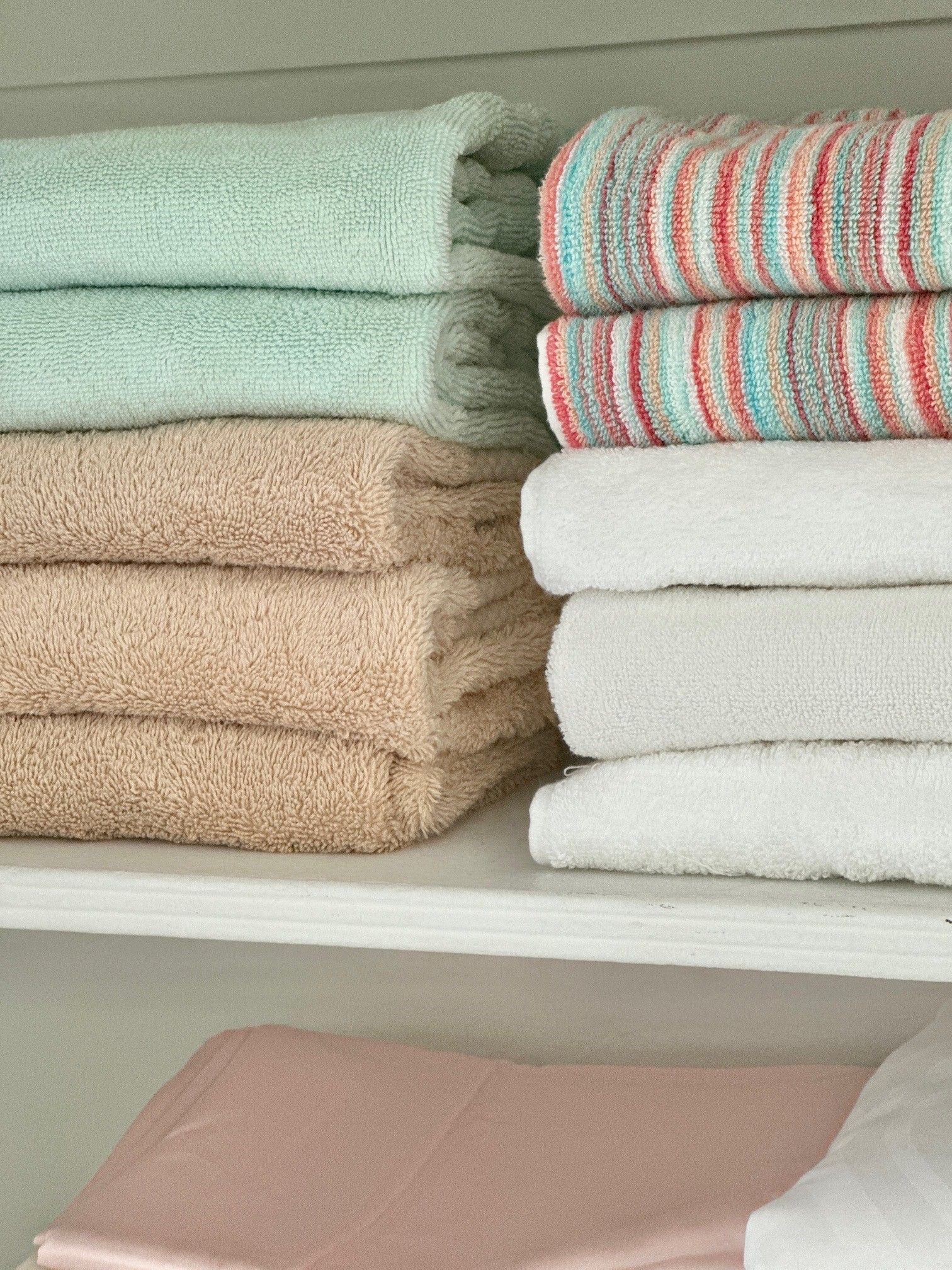 Woman put wicker box with cosmetics products in bathroom closet