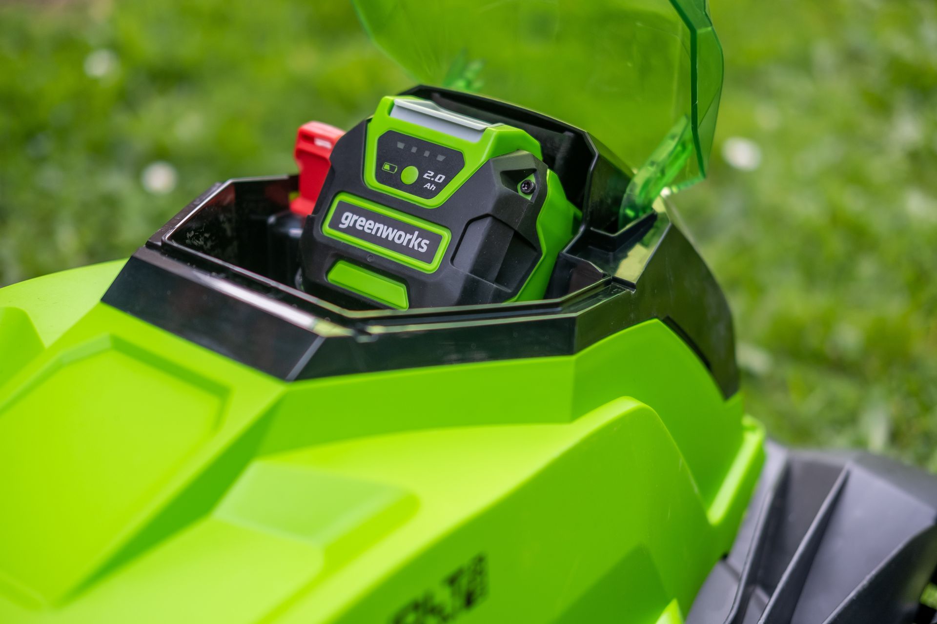 Photograph of Greenworks lithium-ion battery, installed in a Greenworks wheeled, cordless, battery electric mower.