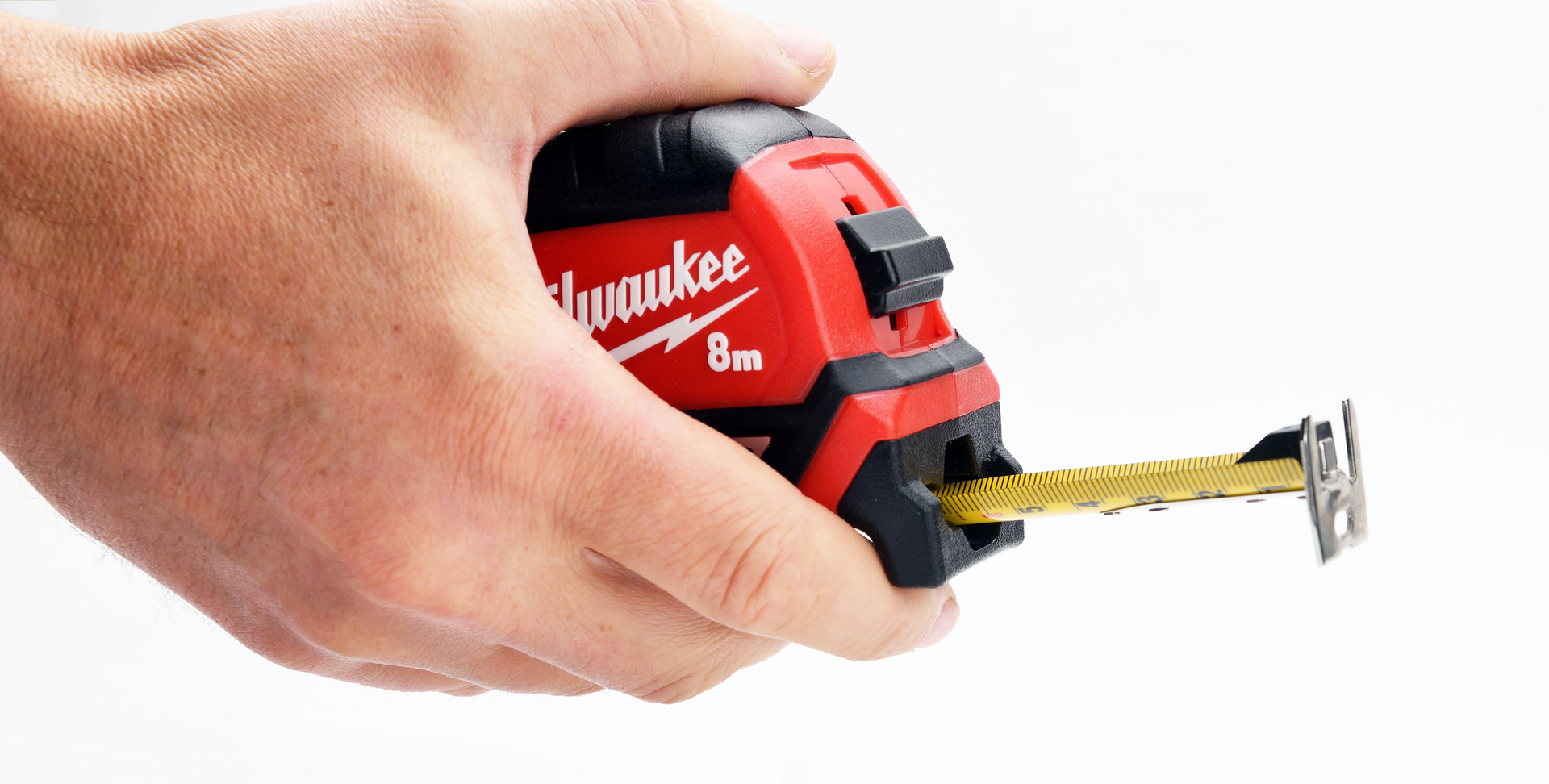 Photograph of person's hand holding a Milwaukee brand, 8m measuring tape.