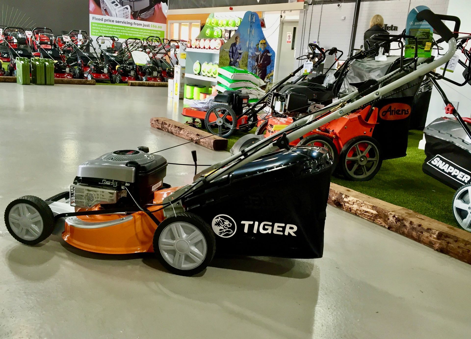 Photograph of a Cyril Johnston Tiger brand, self-propelled, petrol engined lawn mower, with steel cutting deck.