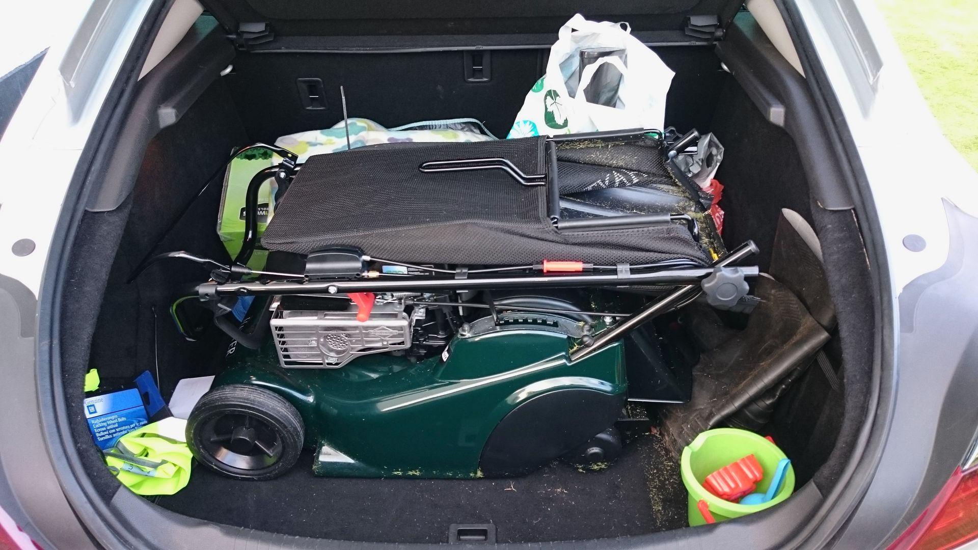Photograph of Hayter Harrier 41 petrol engined lawnmower, placed in the boot of a Vauxhall Insignia hatchback car.