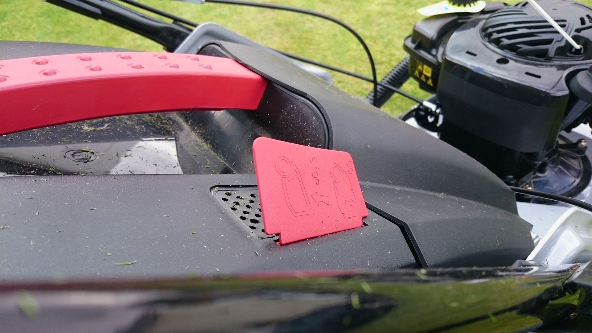 Photograph of a lawnmower grass box indicator in the open position.
