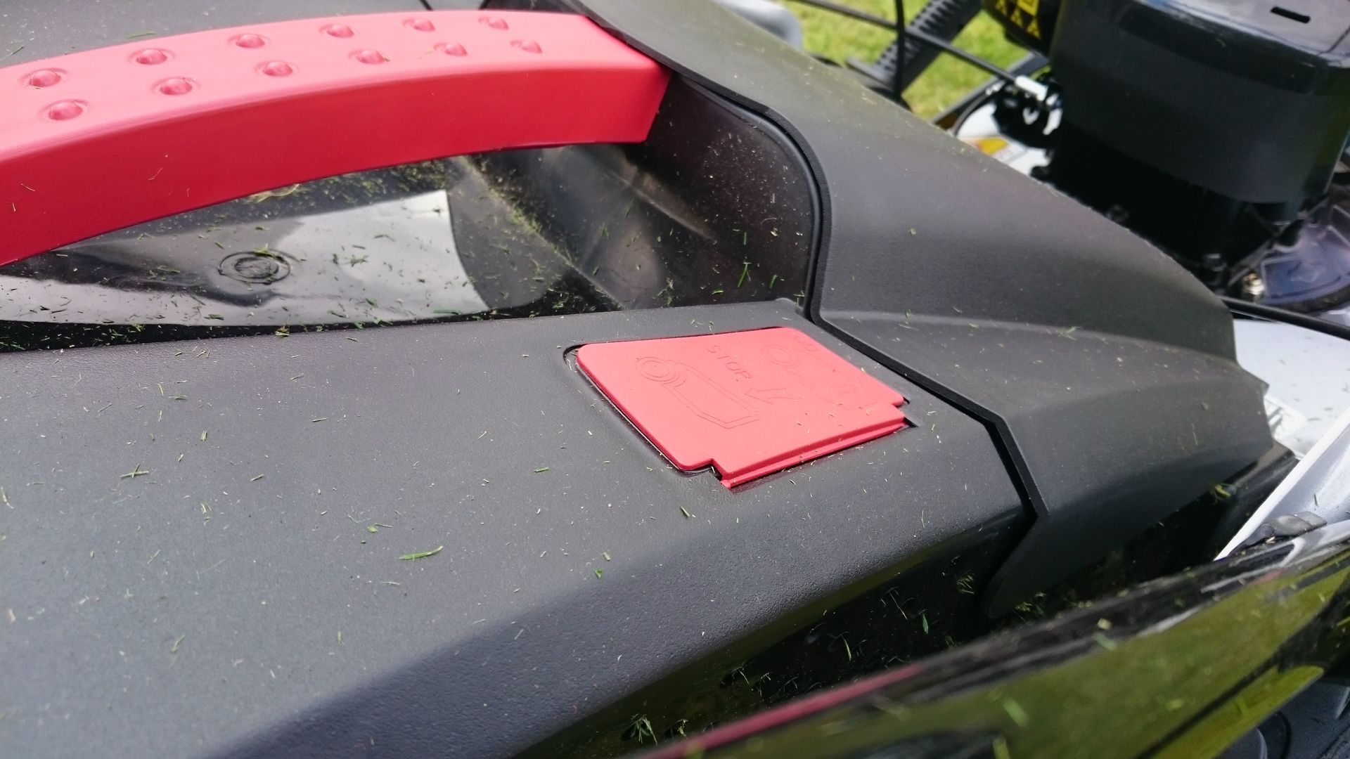 Photograph of a lawnmower grass box indicator in the closed position.