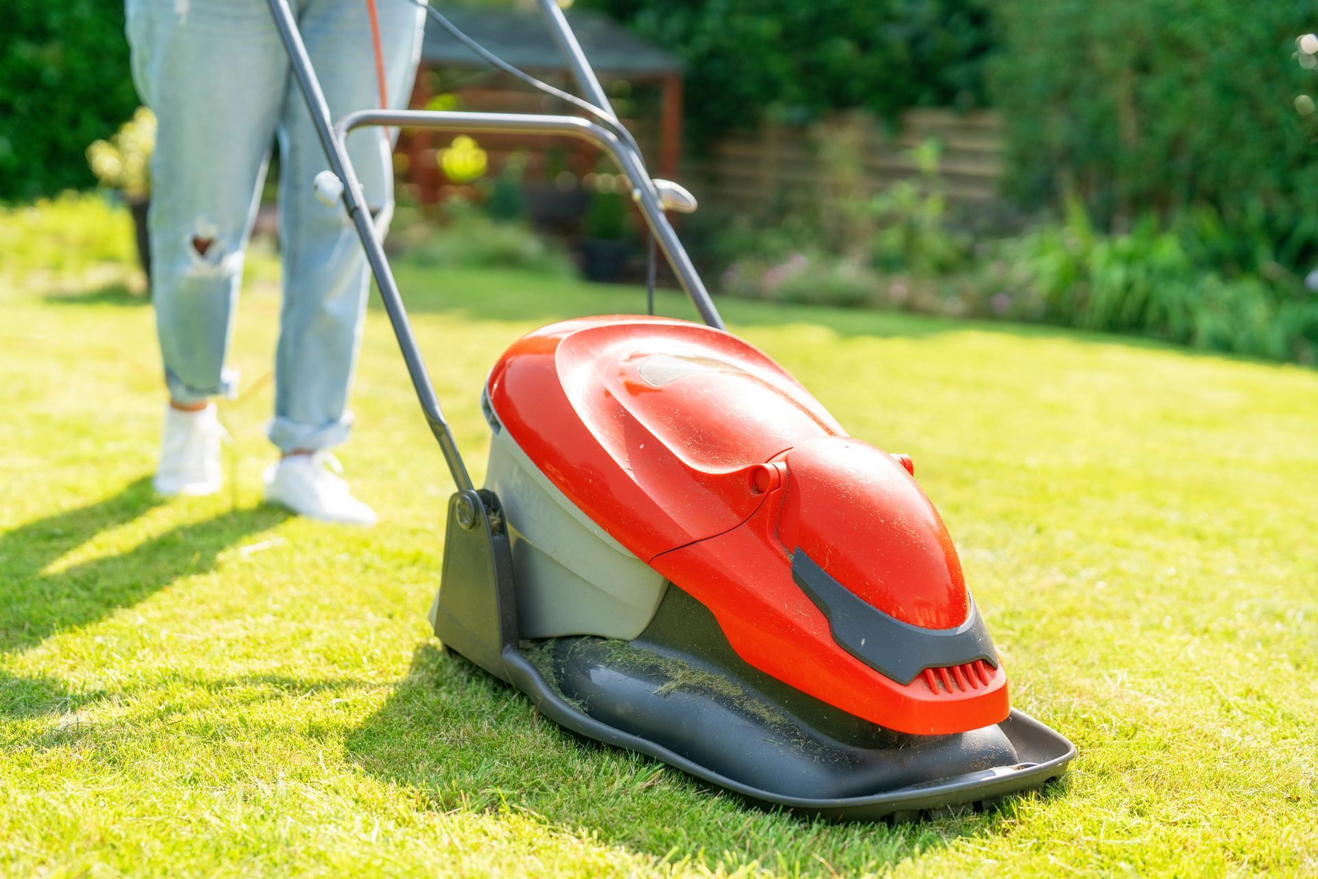 Photograph of a lawn being cut with a corded, electric, Flymo hover mower.