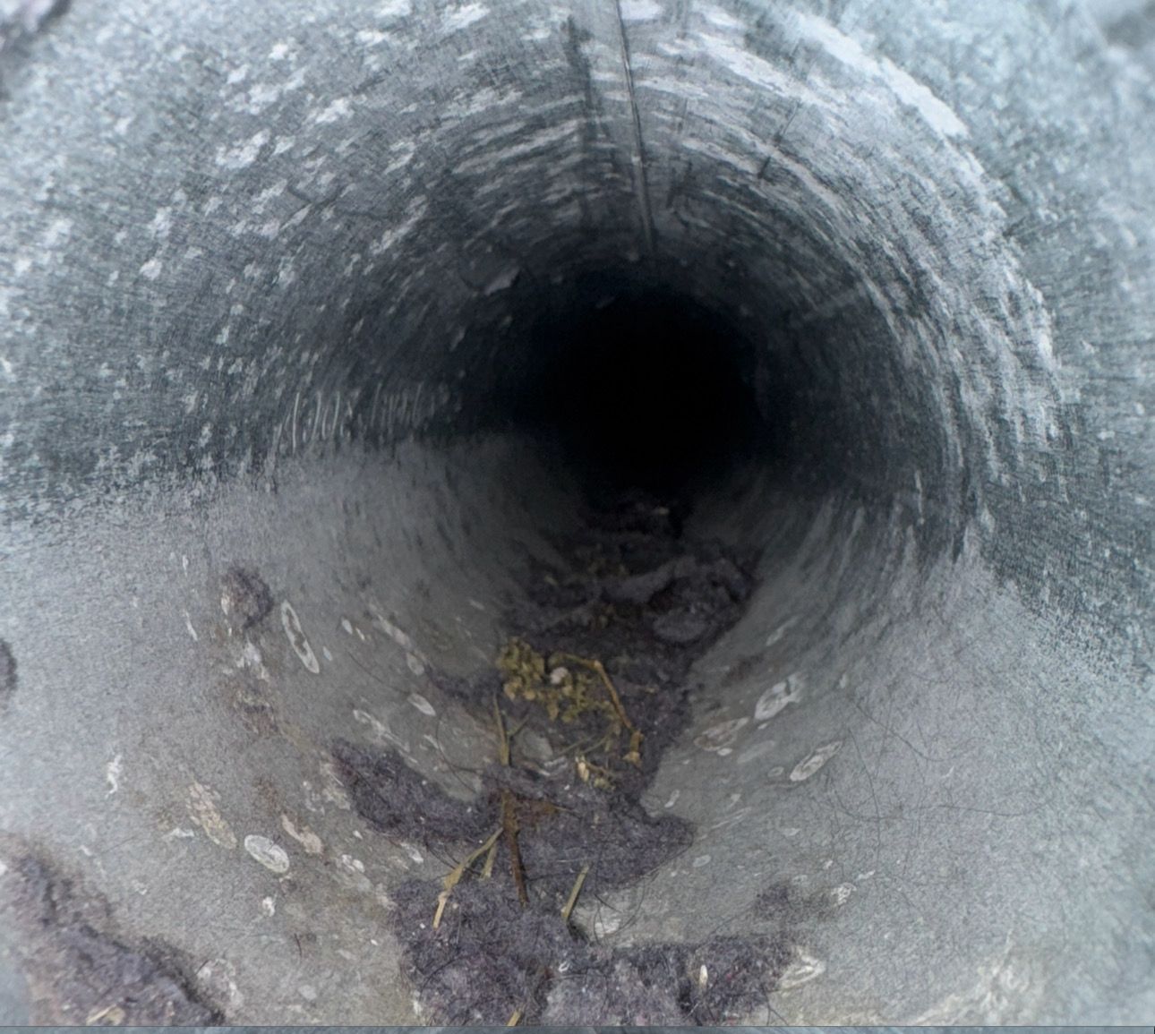 A close up of a dirty pipe with a hole in the middle.