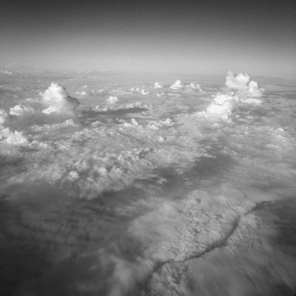 Overhead view of fluffy white clouds filling the sky, some towering and others low-lying.
