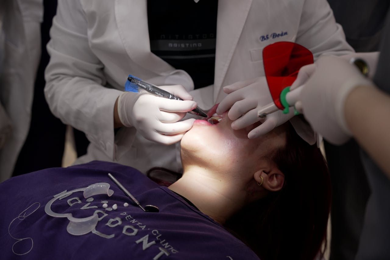 a woman is getting her teeth examined for bone grafting by a dentist.