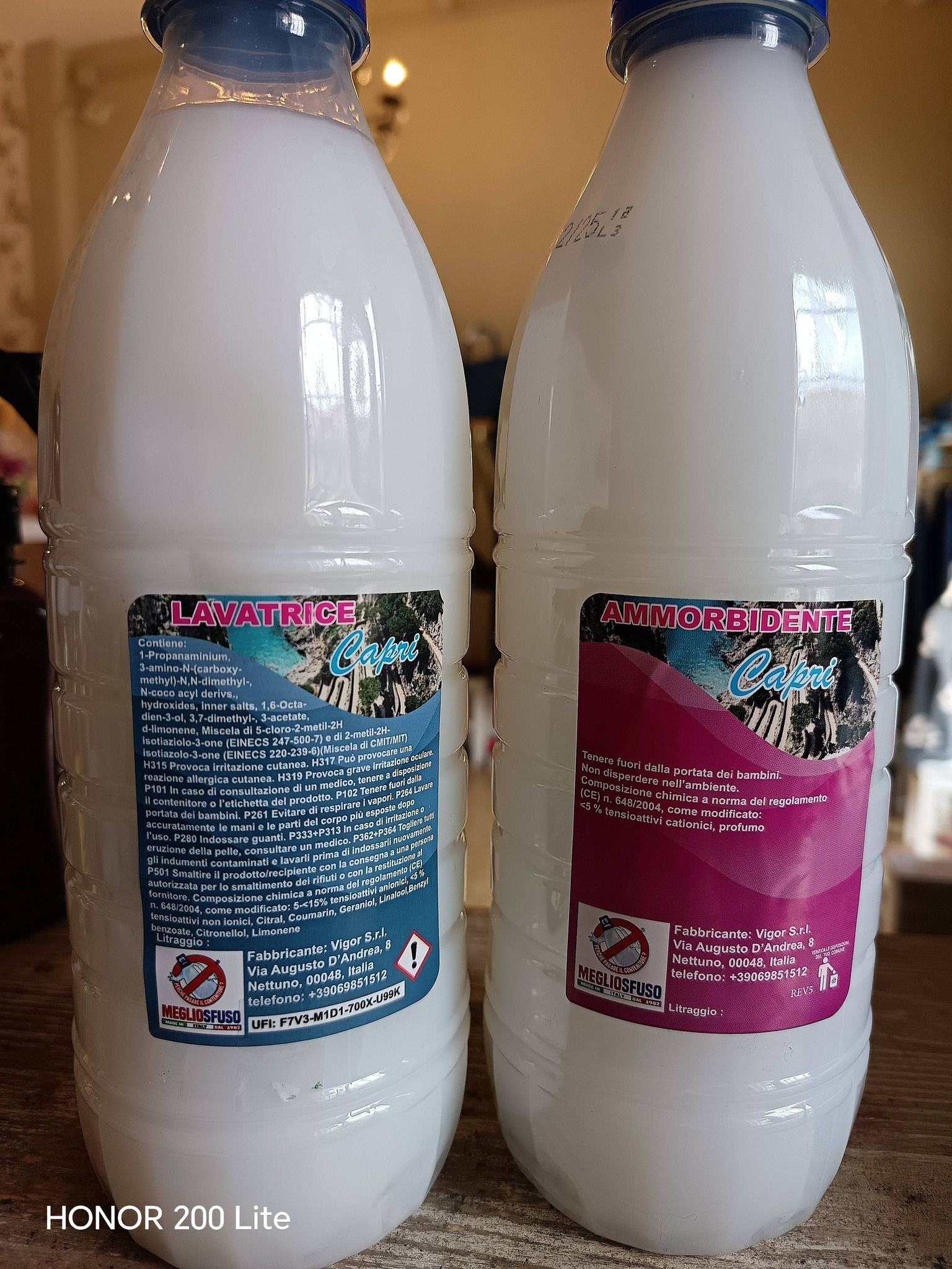 Due bottiglie di plastica bianca con etichette, contenenti liquido, etichette blu e magenta.