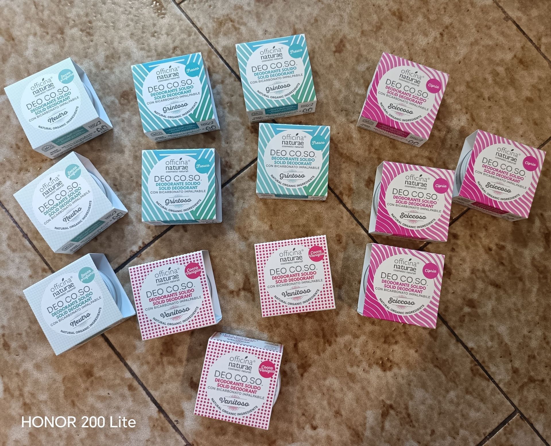 Scatole di sapone blu, bianche e rosa, disposte su una superficie piastrellata marrone.