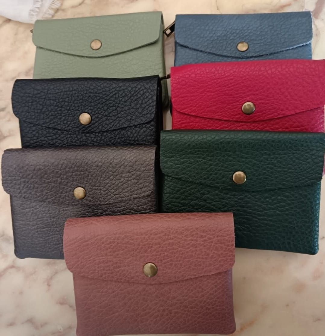 Primo piano di vari portafogli in pelle colorata con chiusura a scatto.