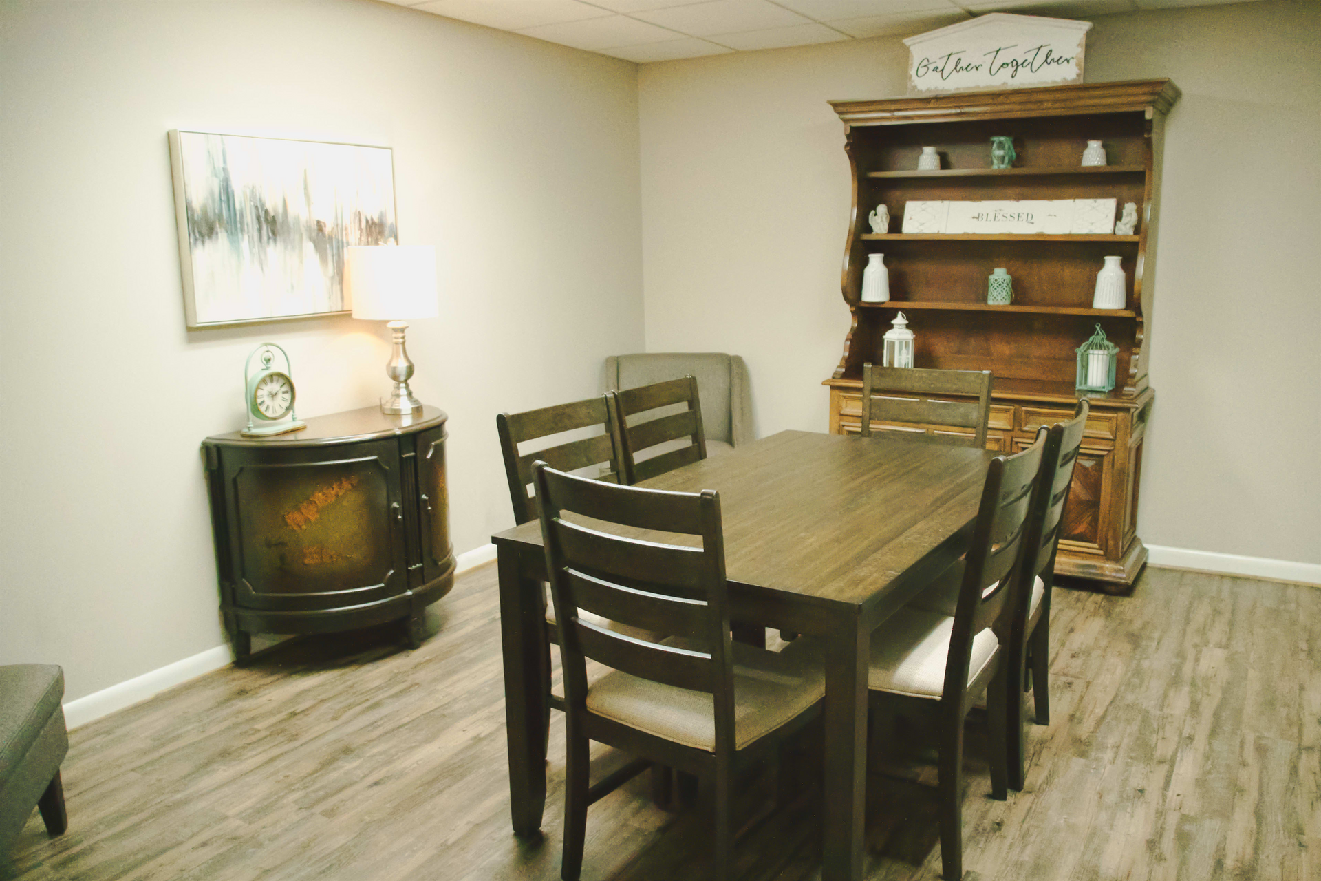 A dining room with a wooden table and chairs and a hutch.