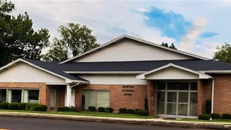 A large brick building with a white trim and a black roof.